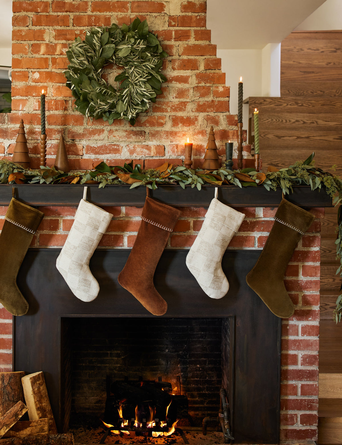 #color::natural | Two Bronson checkerboard pattern stockings hanging with other stockings on a mantel over a fireplace