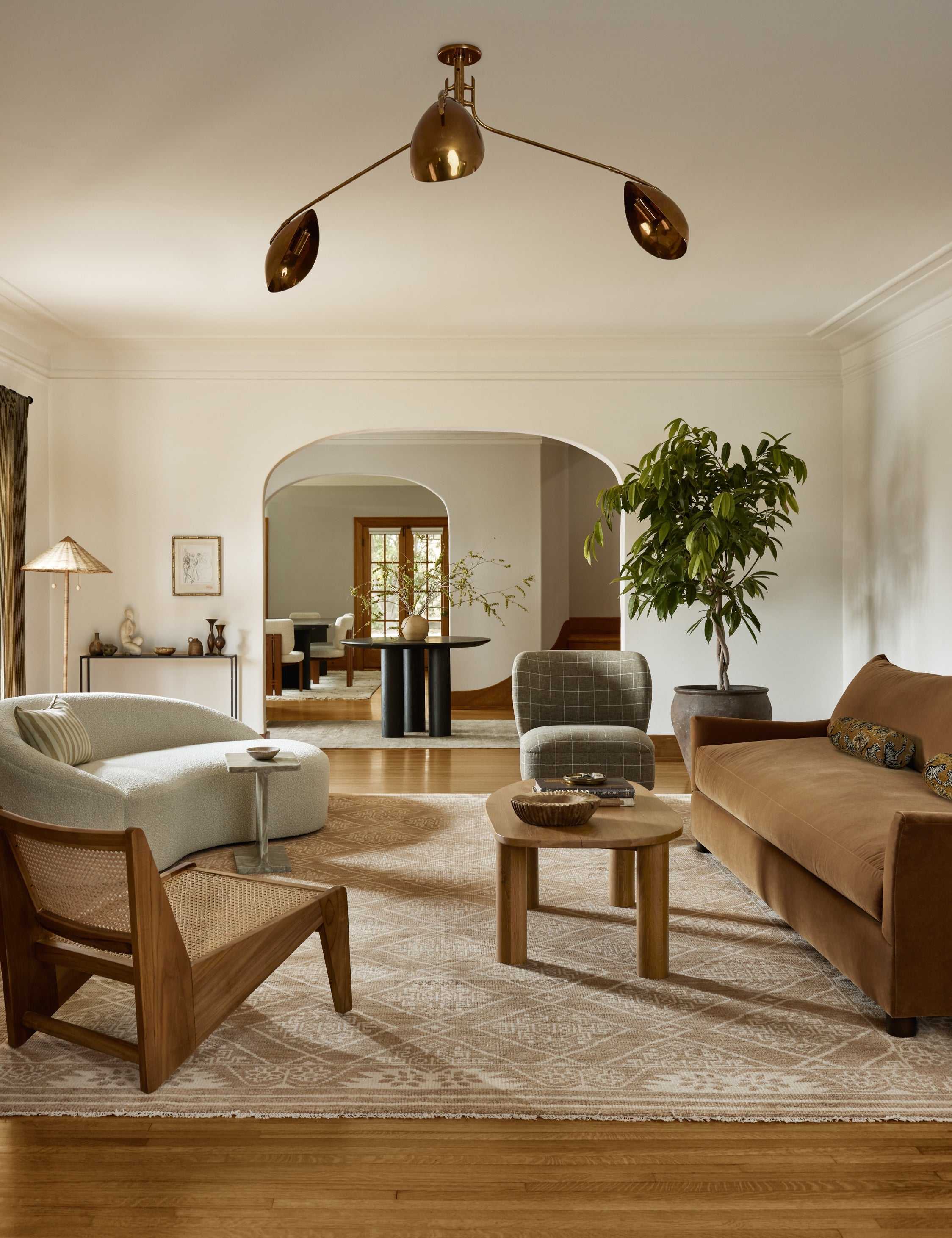 | A living room featuring the Abanu mid-century adjustable brass chandelier.