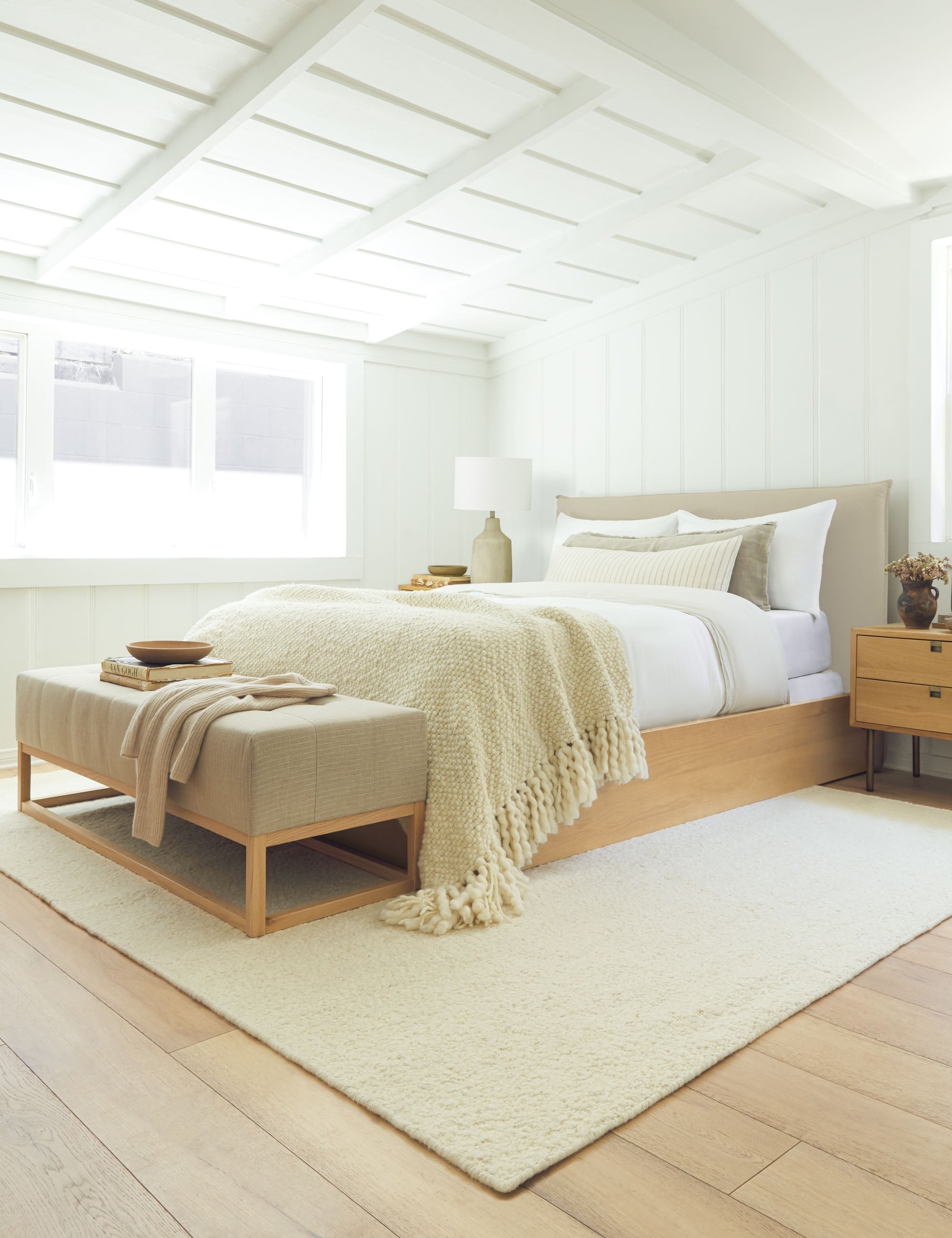 #showall::L0455954 | The Nia natural linen bed sits atop an ivory rug with a linen bench under a white sloped ceiling